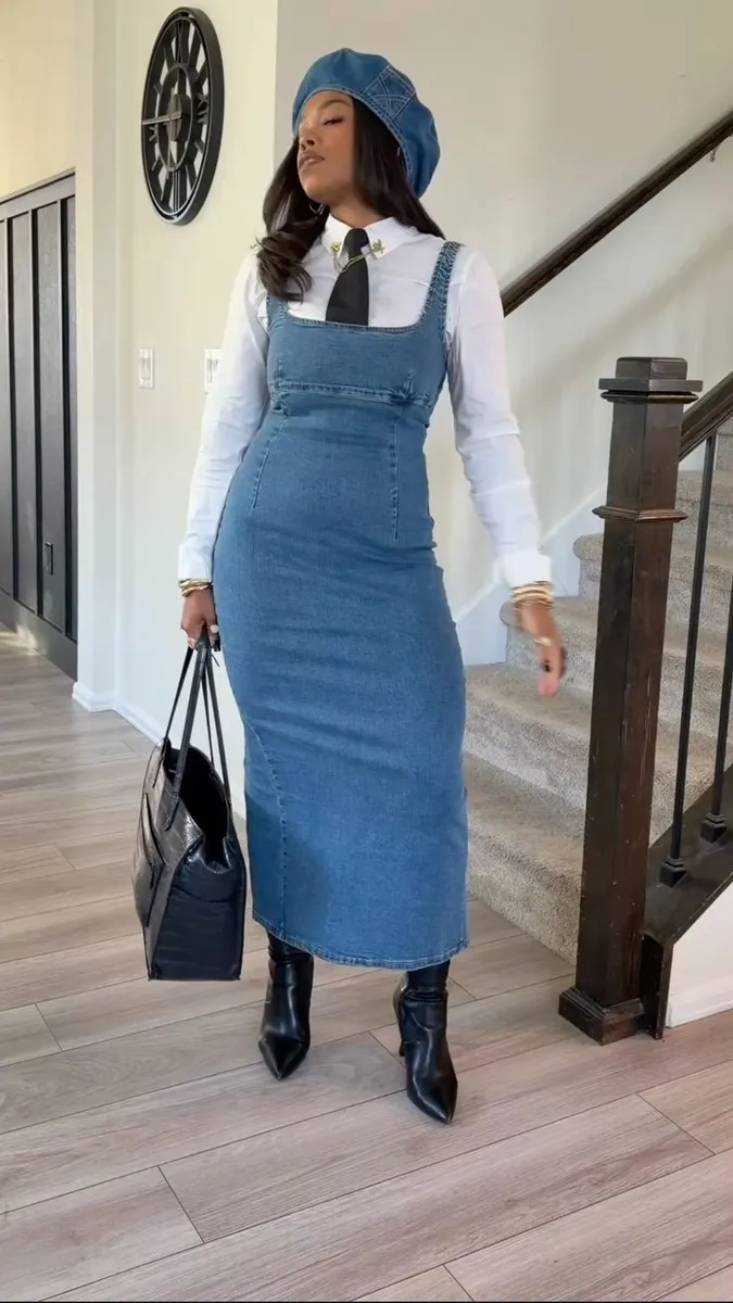 Denim pinafore dress layered over a white shirt with a beret