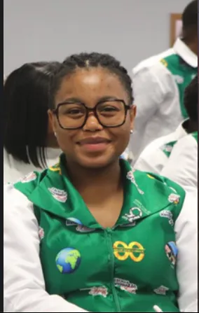 Young woman smiling in a green printed Church Java top