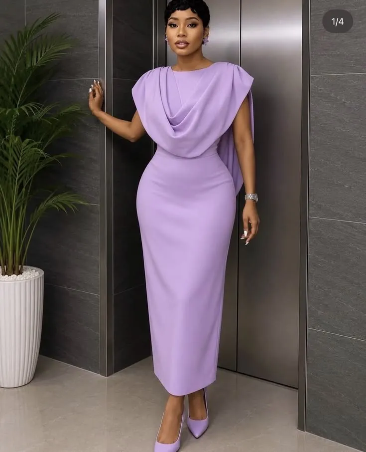 Woman in a lavender draped dress leaning against a wall