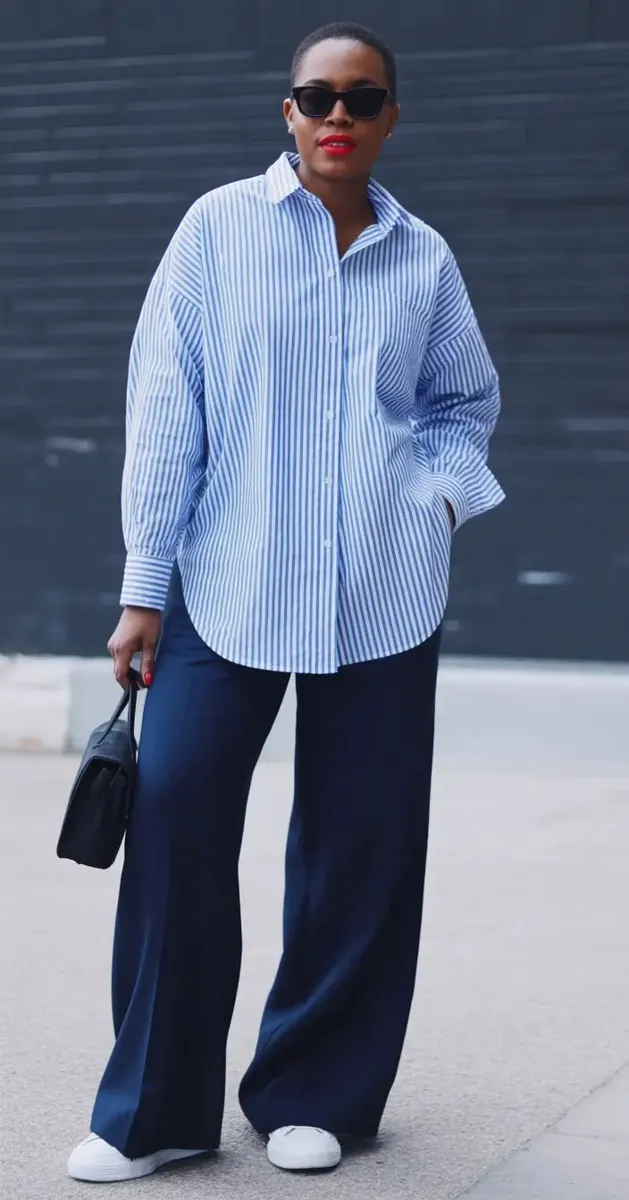 Woman in an oversized light blue shirt with wide-leg navy jeans